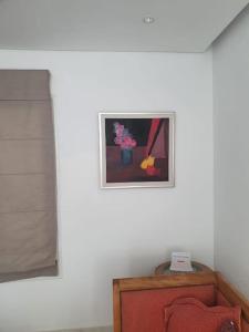 a room with a picture on the wall and a chair at bel appartement vue sur mer in Nabeul