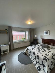 a bedroom with a black and white bed and a window at City Apartment Maaherrankatu, ilmainen kadunvarsipysäköinti in Kuopio