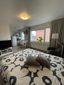 ein Schlafzimmer mit einem großen Bett und ein Wohnzimmer in der Unterkunft City Apartment Maaherrankatu in Kuopio