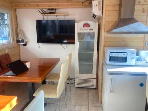 a kitchen and dining room with a table and a tv at Guesthouse Dune in Sofia