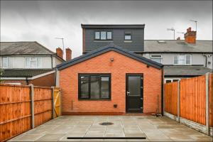 a red brick house with a black door at The Little Oaks House in Birmingham