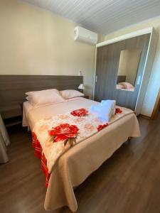 Un dormitorio con una cama grande con flores rojas. en Apartamento Petri, en Gramado