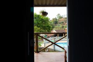 a view from a door of a balcony with a pool at Pousada & Camping Recanto dos Anjos Azuis in Paty do Alferes