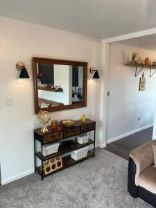 a living room with a table with a mirror at Lake View Retreat in Cambridge
