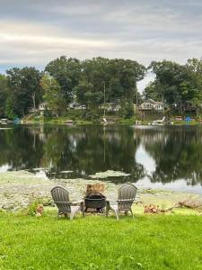 two chairs and a table in front of a lake at Lake View Retreat in Cambridge