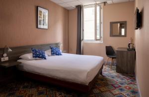 Cette chambre d'hôtel dispose d'un lit avec des oreillers bleus. dans l'établissement The Originals Boutique, Hôtel Danieli, Avignon, à Avignon