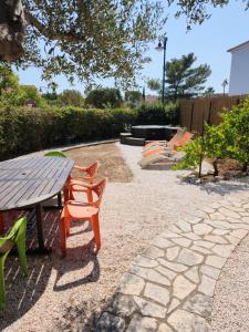 patio con mesa, sillas y parque infantil en Villa Rose, en Le Muy