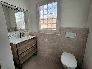 a bathroom with a toilet and a sink and a window at Villa Rose in Le Muy +33 photos