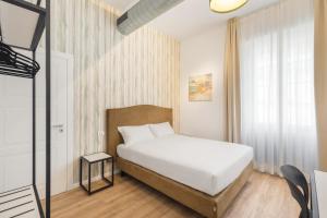 1 dormitorio con cama blanca y ventana en Adelante rooms, en Roma