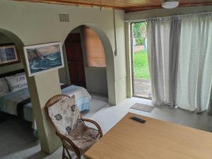 Zimmer mit einem Tisch, einem Bett und einem Fenster in der Unterkunft Fairfield Guest House in Pietermaritzburg