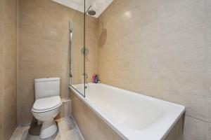 (G3) Grand 2 bed Blythswood Apartment في غلاسكو: حمام مع مرحاض وحوض استحمام