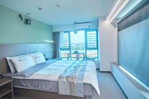 um quarto com uma cama grande e uma janela grande em South Wind Blowing Dreams B&B - Xiamen North Railway Station em Xiamen