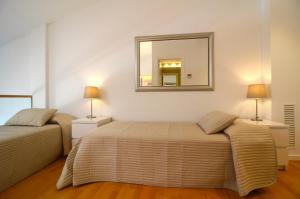 レスタルティットにあるAPARTAMENTO ESGLESIA 7のベッドルーム1室(ベッド2台、壁掛け鏡付)