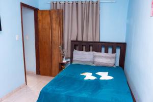 Un dormitorio con una cama con dos cisnes. en Pousada & Camping Recanto dos Anjos Azuis, en Paty do Alferes