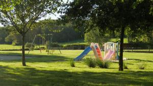 a playground with a slide in a park at Gîtes Ferme de la Barrière in Chimay