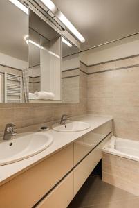 y baño con 2 lavabos, bañera y espejo. en Apartment Alpes IV - Alpes Travel - Central Chamonix (sleeps 4), en Chamonix-Mont-Blanc