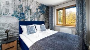 a blue and white bedroom with a bed and a window at Apartamenty Good Time- Centrum, blisko wyciągu i szlaków in Szklarska Poręba