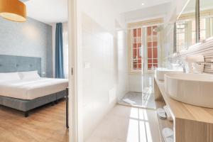 a bathroom with a bed and a sink and a mirror at Adelante rooms in Rome