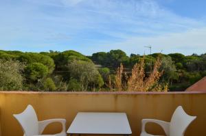 een tafel en stoelen op een balkon met uitzicht bij augustha resort in Islantilla