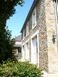 a brick house with white windows and bushes at Résidence du Prieuré in Dinard