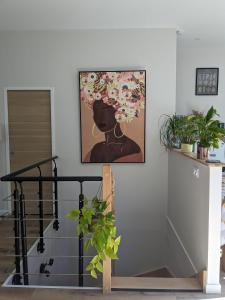 杜薩爾的住宿－Maison entre lac et montagnes，墙上一幅画画,画着一个花朵的女人