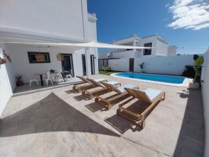 a patio with lounge chairs and a swimming pool at Villa Stefi in Playa Blanca