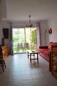 sala de estar con sofá rojo y mesa en augustha resort, en Islantilla
