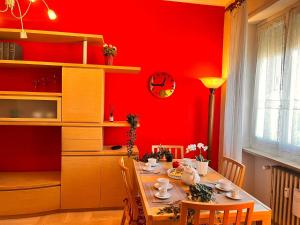 comedor con mesa y paredes rojas en sky apartment a due passi dalla stazione, en Collegno
