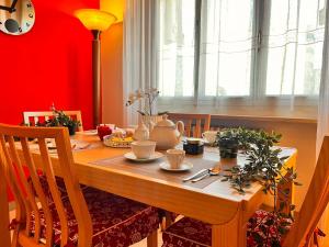 a dining room with a wooden table and red walls at sky apartment a due passi dalla stazione in Collegno