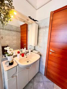 baño con lavabo y puerta de madera en sky apartment a due passi dalla stazione, en Collegno