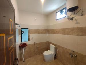 a bathroom with a toilet and a window at RPM home stay in Tiruvannāmalai