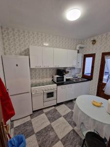 eine Küche mit einem weißen Kühlschrank und einem Tisch in der Unterkunft Casa Victoria in Bargas