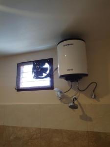 a television with a camera on a wall next to a lamp at RPM home stay in Tiruvannāmalai