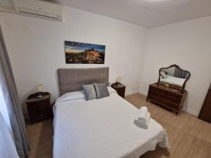 1 dormitorio con 1 cama, 2 mesas y espejo en Casa Victoria, en Bargas