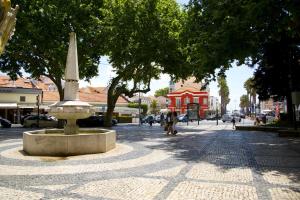 a street with a fountain in the middle of a city at Casa da Fonte - Holiday Apartments in Cascais +63 photos