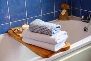 a pile of towels on a wooden tray on a bath tub at Waterfront Self Catering Houses in Carrick on Shannon