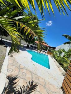 una piscina junto a una casa con una palmera en Pa' la Finca, en Concepción de La Vega