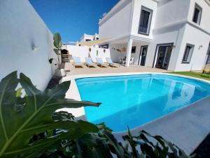 a villa with a swimming pool in front of a house at Villa Stefi in Playa Blanca