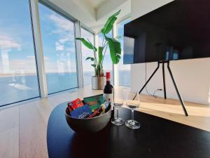 a table with a bottle of wine and a glass at Tranquil apartment with panorama view over ocean above 20th floor in Aarhus