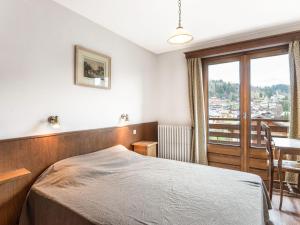 梅傑夫的住宿－Appartement Megève, 3 pièces, 4 personnes - FR-1-453-80，一间卧室配有一张床、一张桌子和一个窗户。