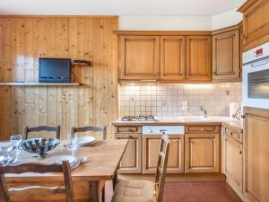 uma cozinha com uma mesa de madeira, uma mesa e cadeiras em Appartement Megève, 3 pièces, 4 personnes - FR-1-453-80 em Megève