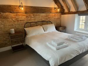 a bedroom with a bed with two towels on it at Seven Abbey Lane in Southam