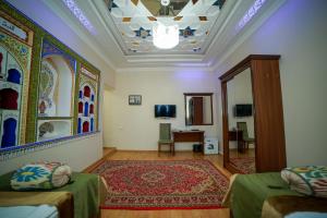 a room with two beds and a mirror at Hotel "RAYHON" in Bukhara