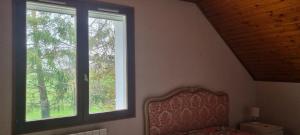 a bedroom with a bed and two windows at Location chambre dans villa in Villers-Robert +1 photo