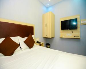 a bedroom with a bed and a tv on the wall at Hotel sunrise cave in Surat