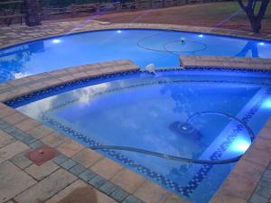 a swimming pool with a hose in a backyard at night at The Hank Maribashoek Adventure Lodge in Mokopane