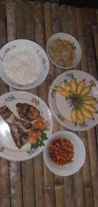 un grupo de platos de comida en una mesa en Delima Cottage, Ngurbloat Beach en Ngurblut