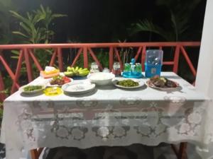 a table with plates of food sitting on it at Delima Cottage, Ngurbloat Beach in Ngurblut