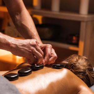 une femme recevant un massage d'un thérapeute dans l'établissement Ведмежа гора Panorama Spa Resort, à Yaremtche