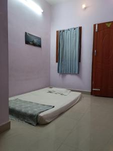 a bed sitting in a room with a window at Full Moon House Tiruvannamalai in Tiruvannāmalai